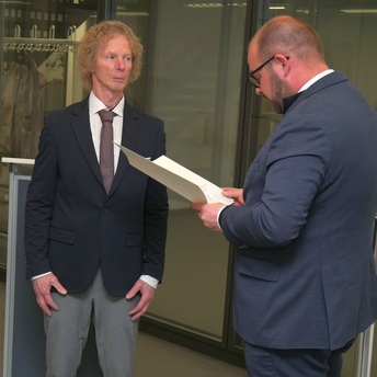 Landrat Sebastian Straubel verliest die Urkunde für Hartmut Jahn, der neben ihm steht.