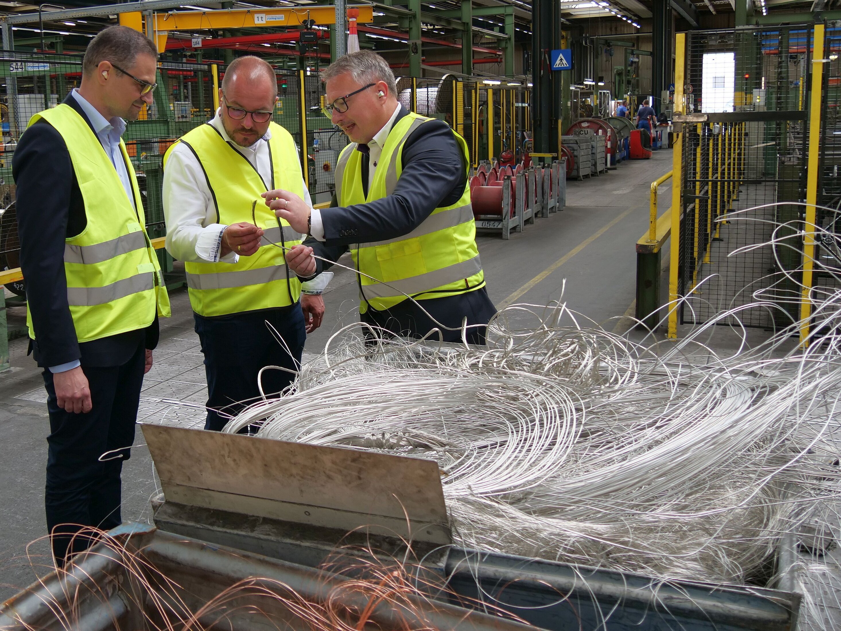 Kabel und ihr Innenleben: Milan Orel, Sebastian Straubel und Lucca Varriale (von rechts) beim Rundgang durch den Fertigungsbereich des Prysmian-Kabelwerks in Neustadt.