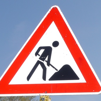 Symbolbild: das Warnschild für eine Baustelle im Straßenverkehr